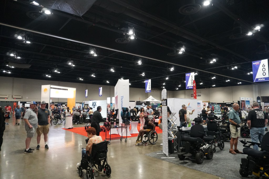 Near the entrance to the expo, a wide view of several vendors, with the wheelchair repair station within view.