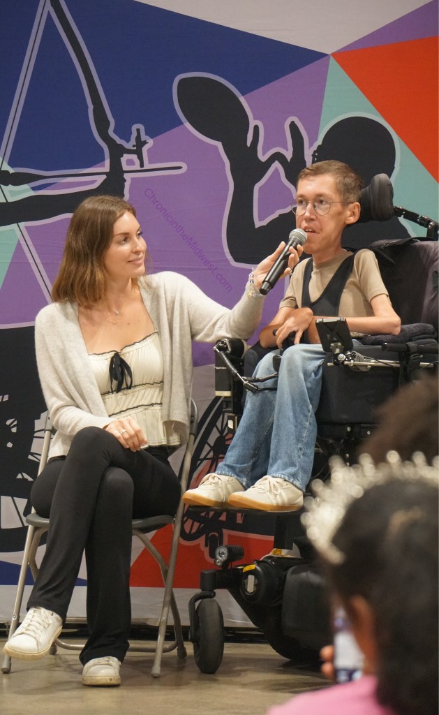 Hannah holds the mic for Shane as he answers a question.